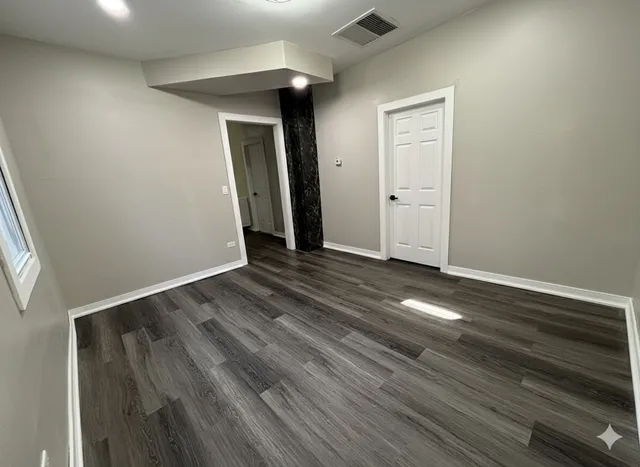 an empty room with wooden floor and closet