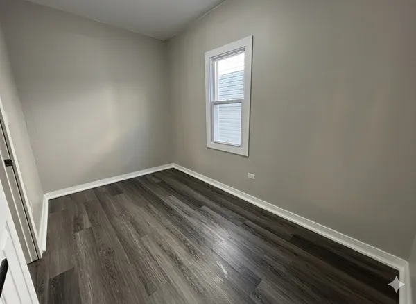 a view of a room with wooden floor and window