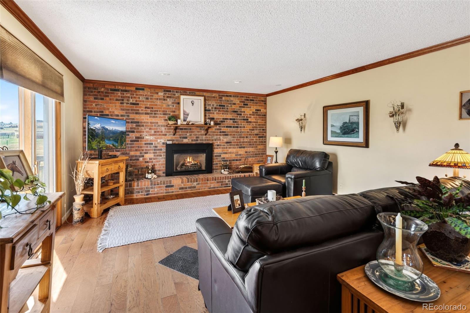 12360 South Mesa View Road Larkspur, CO 80118 - Photo 11 of 50 a living room with furniture fireplace and a large window