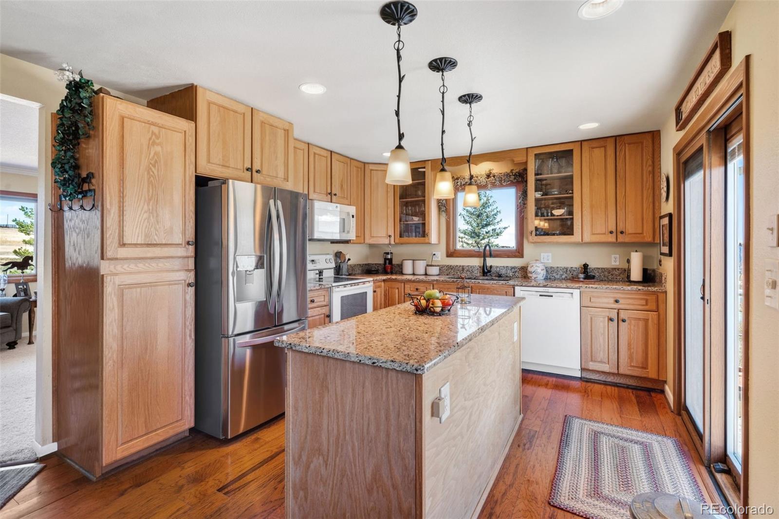 12360 South Mesa View Road Larkspur, CO 80118 - Photo 8 of 50 a kitchen with refrigerator a sink and cabinets