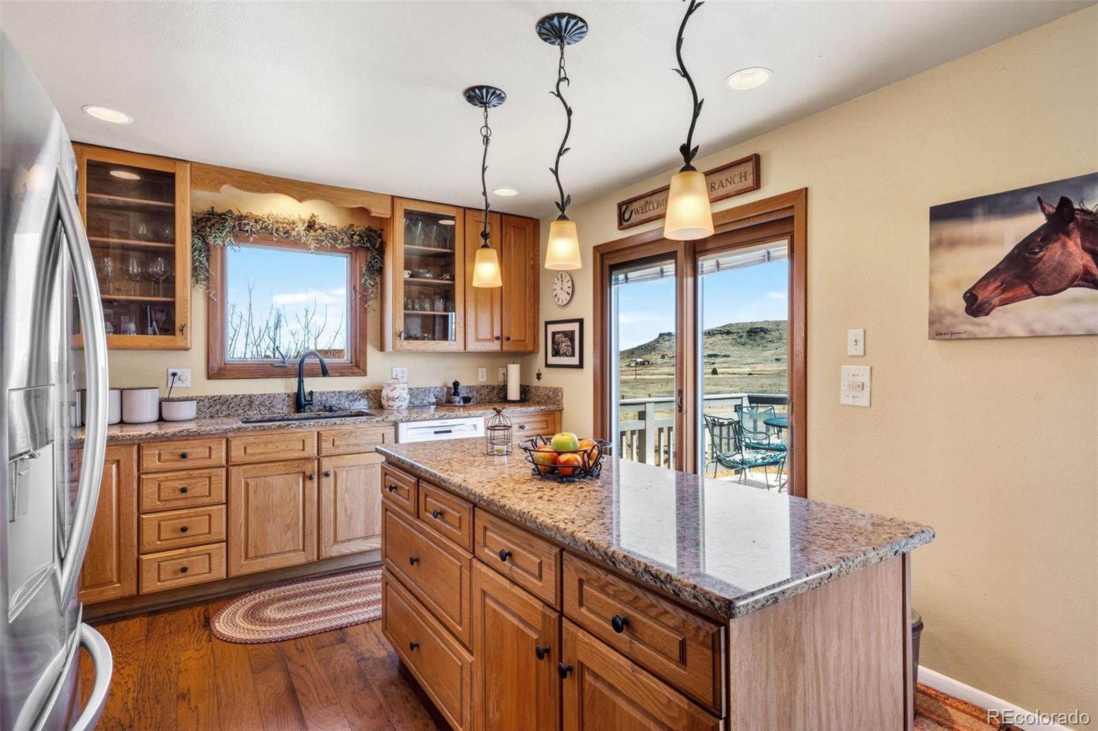 12360 South Mesa View Road Larkspur, CO 80118 - Photo 10 of 50 a kitchen with a sink stove and wooden cabinets