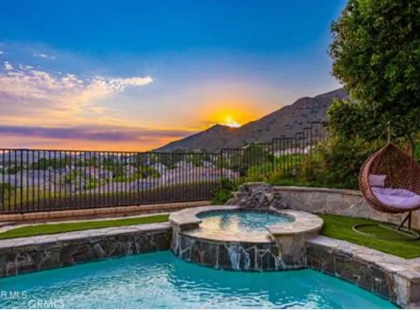 a view of a backyard with swimming pool and a yard