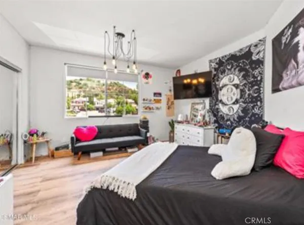 a bedroom with a bed window and flat screen tv