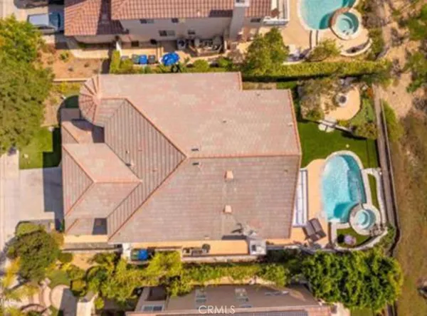 an aerial view of a house with a yard and large trees