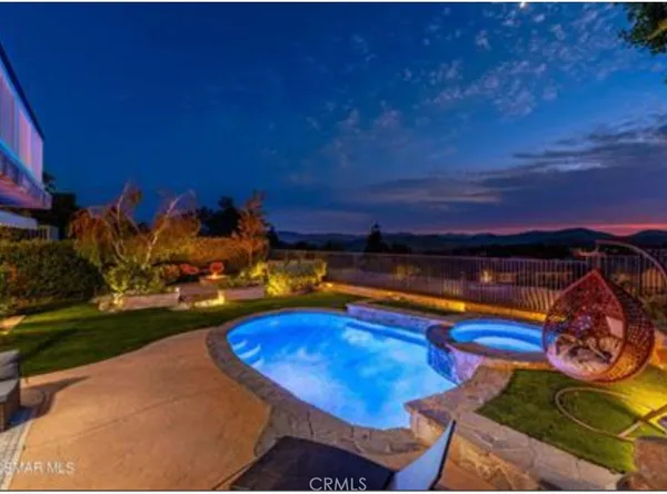 a view of a pool a fire pit and outdoor seating