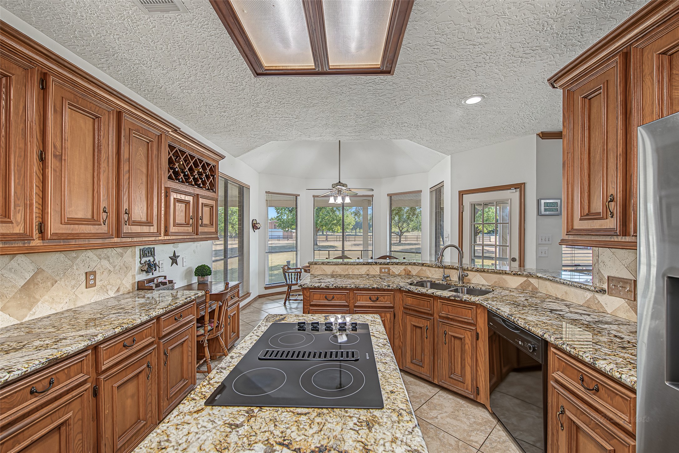 1345 Peach Ridge Road Brookshire, TX 77423 - Photo 25 of 50 Enclosed by stone-look tile flooring and framed wood lighting fixtures, this light-filled layout offers the ideal setting to host gatherings or enjoy quiet daily cooking.