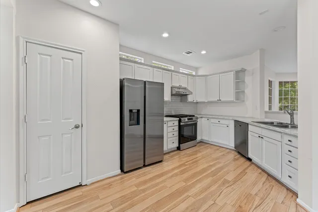 a kitchen with stainless steel appliances a refrigerator sink and cabinets