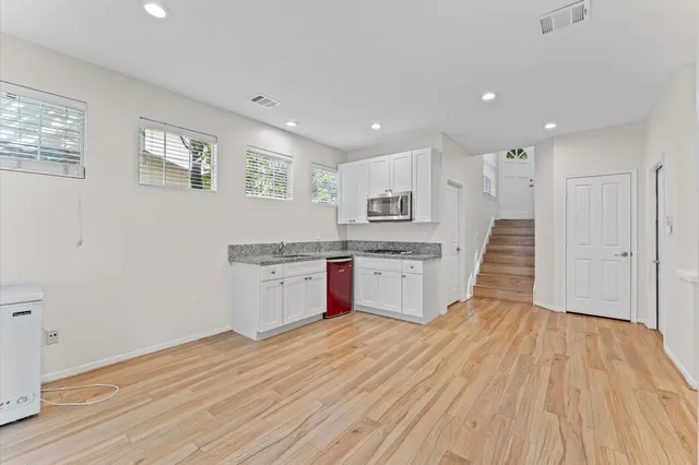 a view of kitchen with wooden floor and electronic appliances