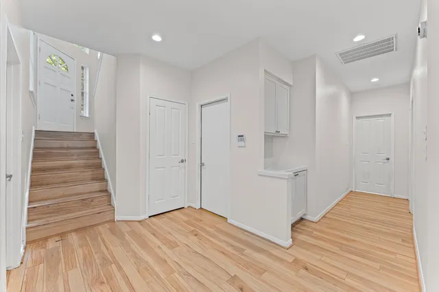 a view of a hallway with wooden floor and staircase