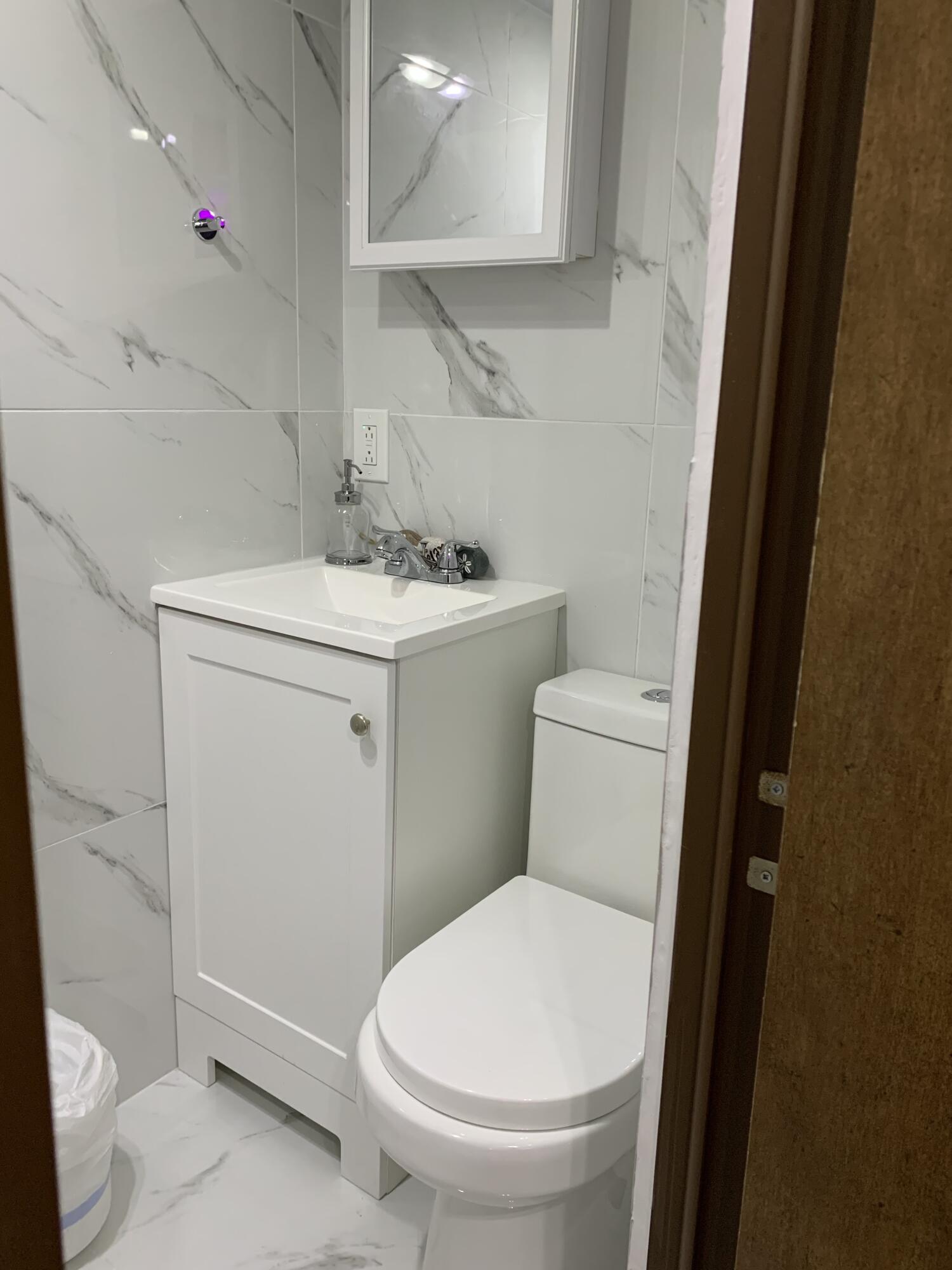 325 Calusa Street, Unit 120 Key Largo, FL 33037 - Photo 13 of 20 a white toilet sitting next to a bathroom sink
