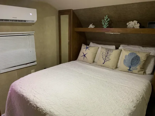 a large bed sitting in a bedroom next to a window