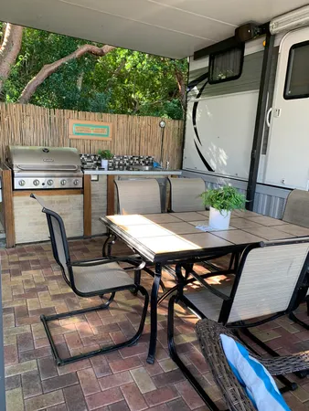 a backyard of a house with barbeque oven table and chairs