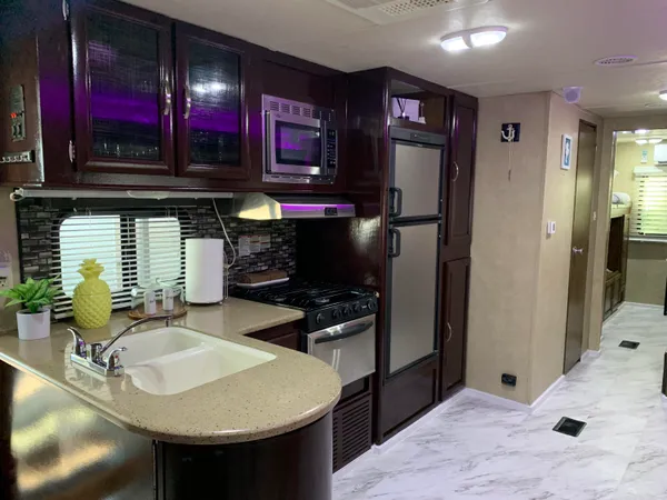 a kitchen with stainless steel appliances granite countertop a sink and a refrigerator