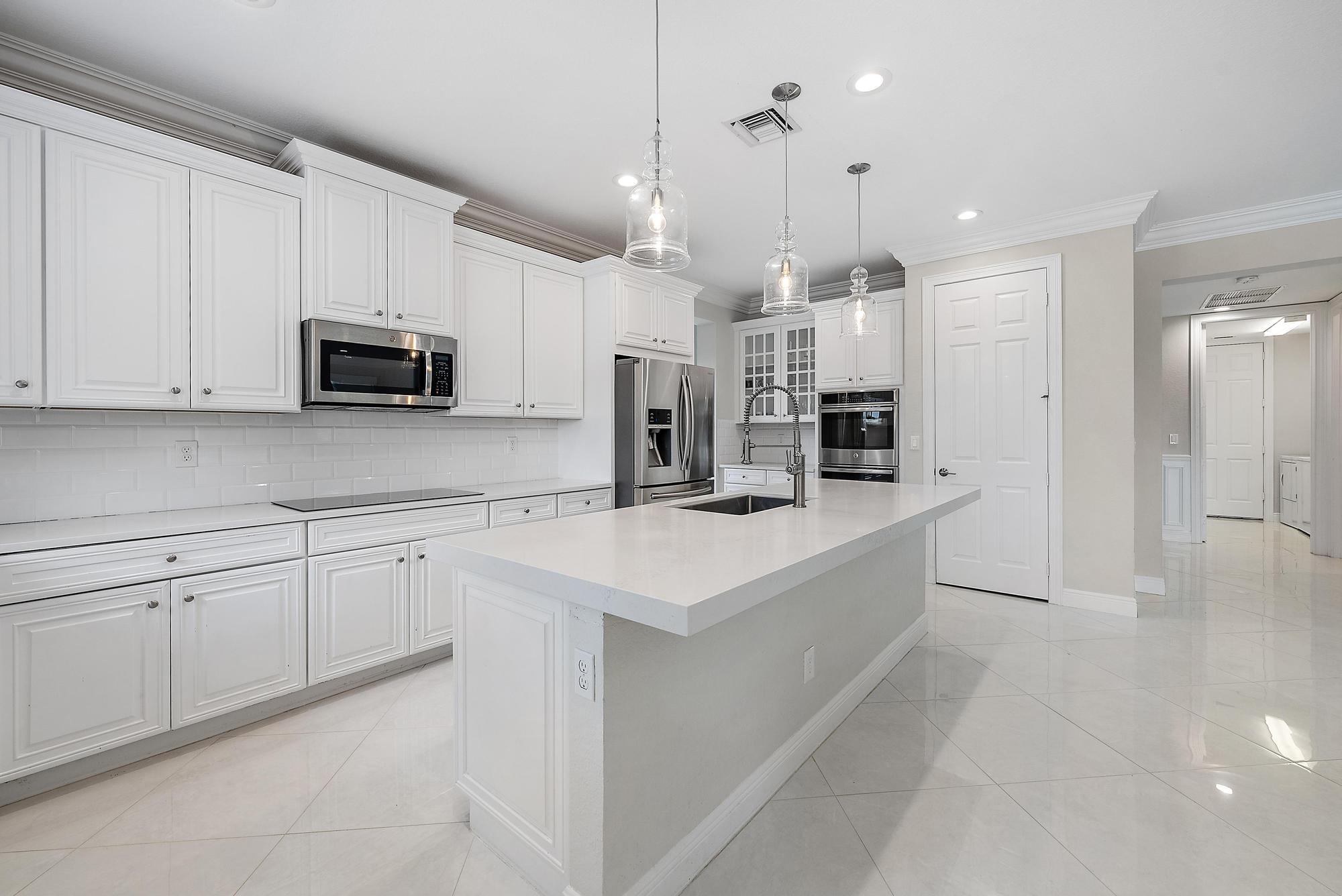 314 Rudder Cay Way Jupiter, FL 33458 - Photo 11 of 66 a kitchen with kitchen island granite countertop a sink a counter top space stainless steel appliances and cabinets