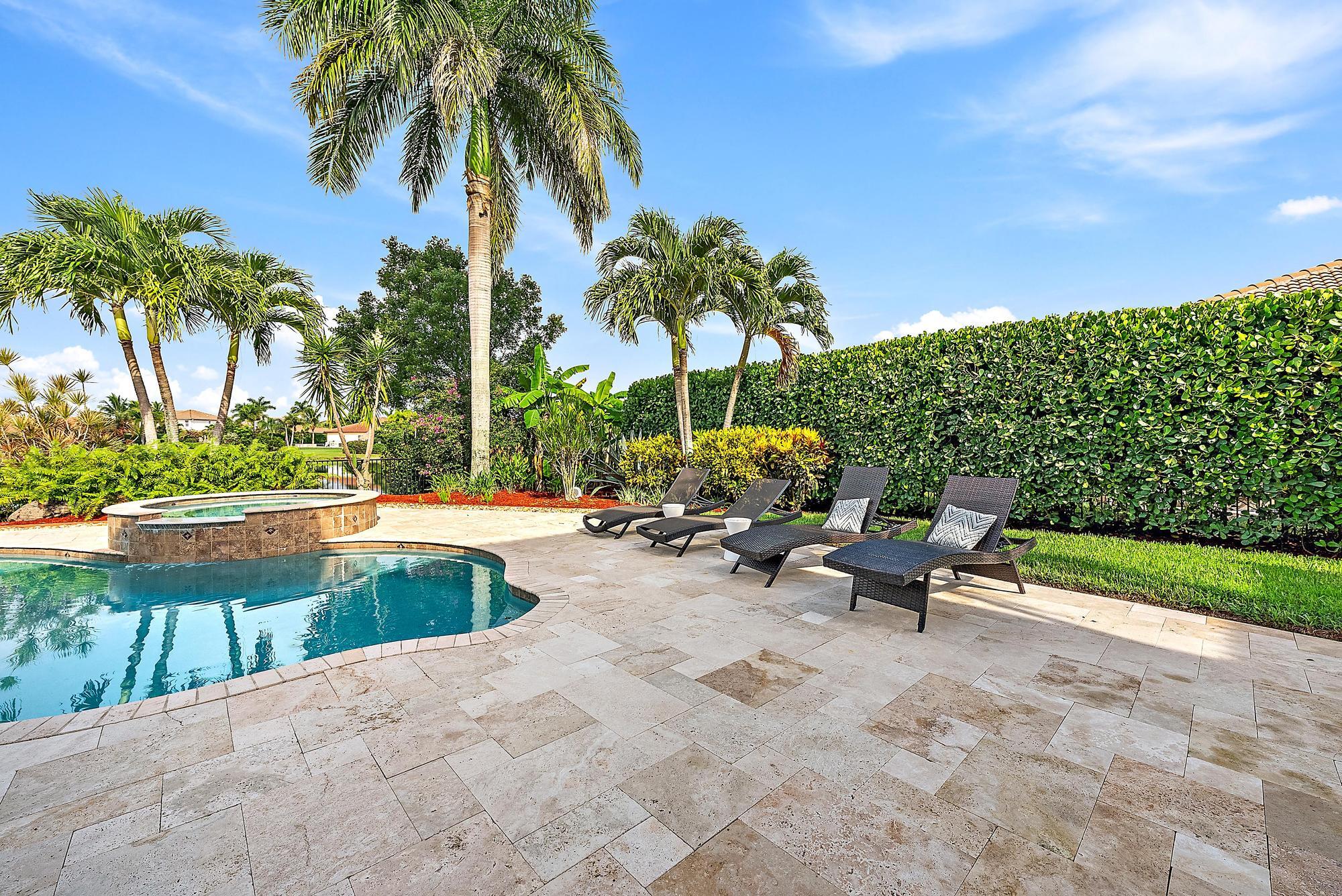 314 Rudder Cay Way Jupiter, FL 33458 - Photo 44 of 66 a row of palm trees and swimming pool in the backyard of a house