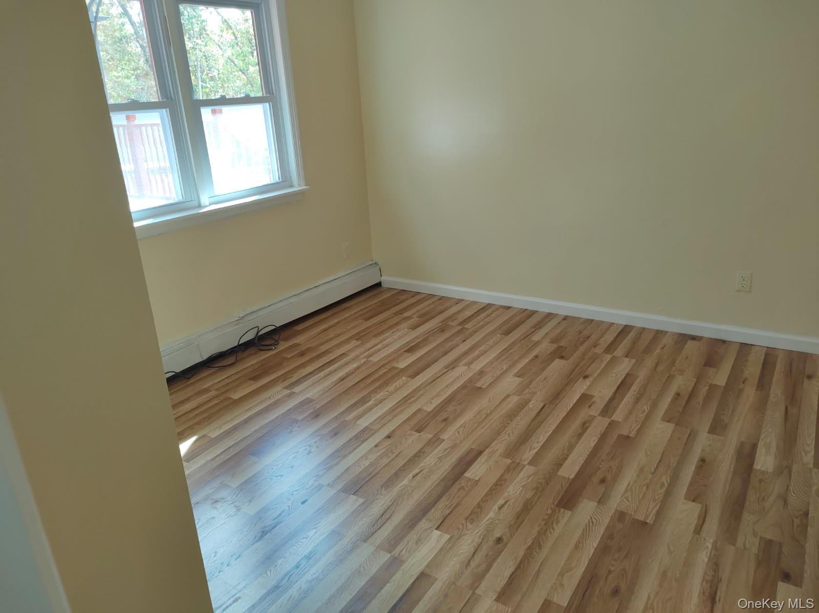41 Woodbrook Drive Ridge, NY 11961 - Photo 13 of 15 an empty room with wooden floor and windows