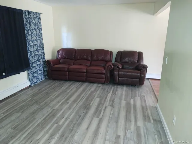 a living room with a couch wooden floor and a fireplace