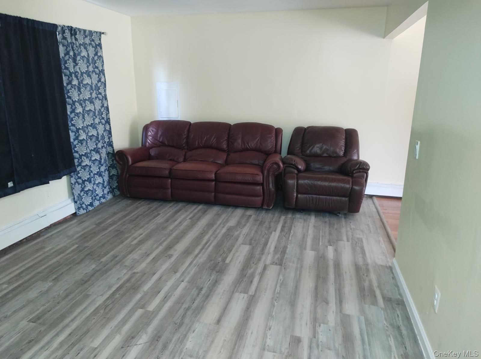 41 Woodbrook Drive Ridge, NY 11961 - Photo 2 of 15 a living room with a couch wooden floor and a fireplace