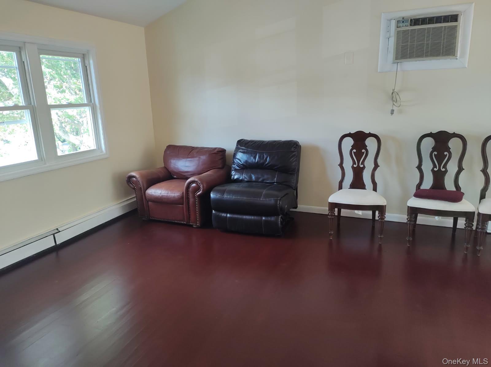 41 Woodbrook Drive Ridge, NY 11961 - Photo 5 of 15 a living room with couches and a potted plant next to a window