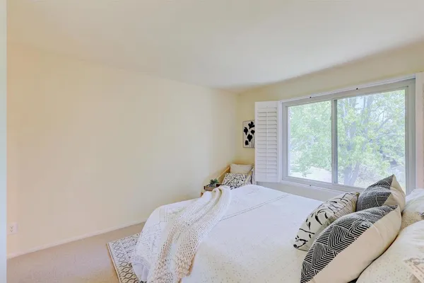 a bed sitting in a bedroom next to a window