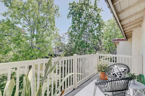 a side of a house with wooden floor outdoor seating