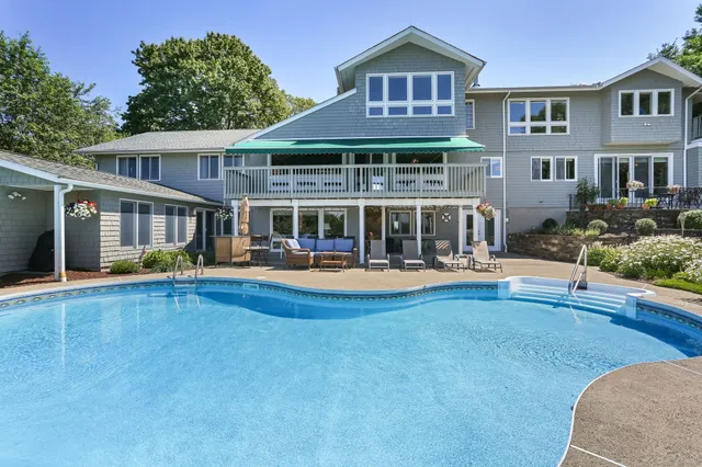 a view of house with a large pool and deck