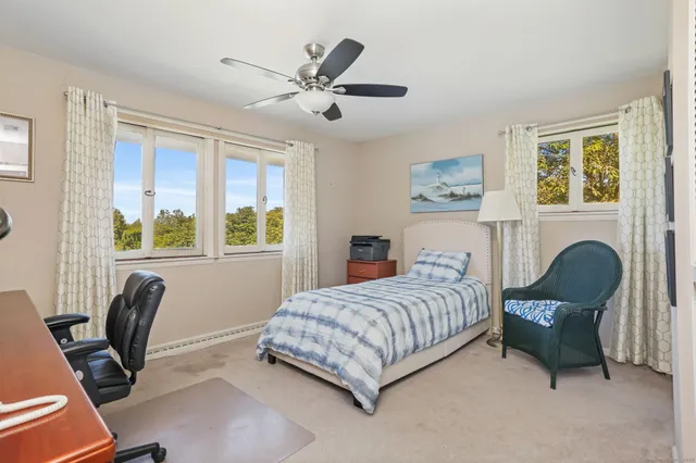 a bedroom with a bed chairs and a window