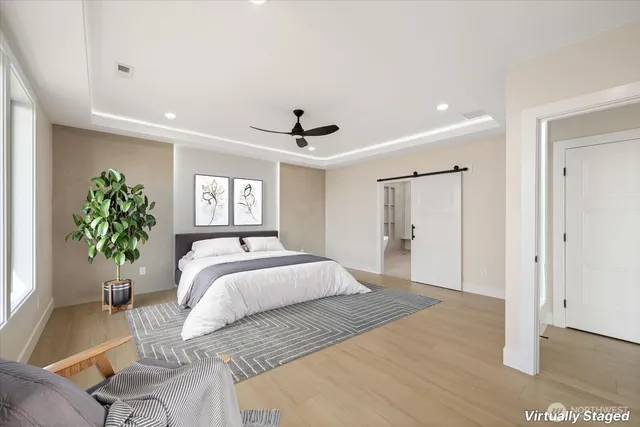 a spacious bedroom with a bed and a potted plant