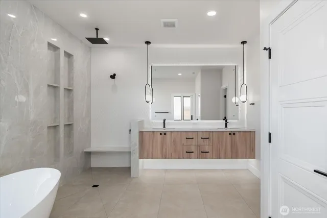 a spacious bathroom with a tub sink shower and mirror