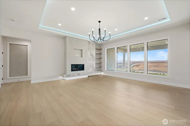 an empty room with fireplace and windows