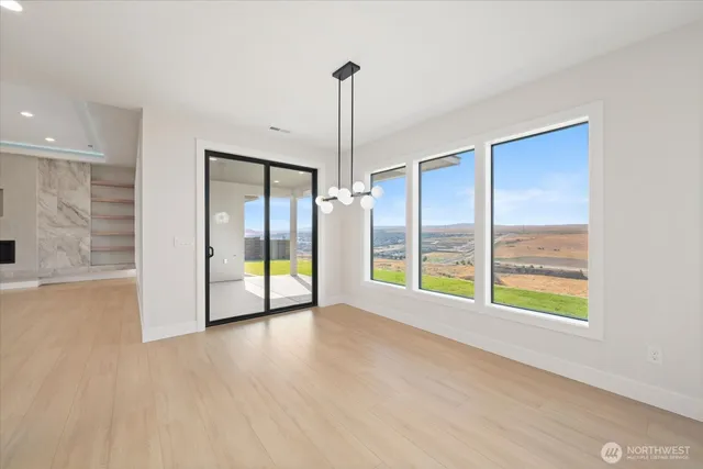 a view of an empty room with glass door and windows