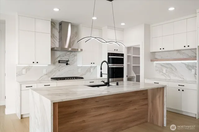 a kitchen with kitchen island a sink stainless steel appliances and cabinets
