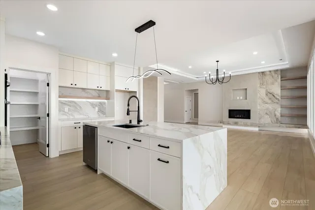 a kitchen with kitchen island a sink stainless steel appliances and wooden floor