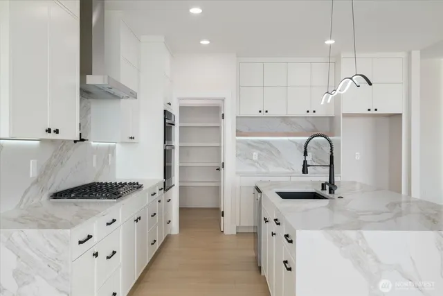 a kitchen with granite countertop a sink stove and cabinets