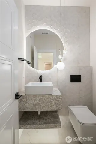 a bathroom with a sink a toilet and mirror