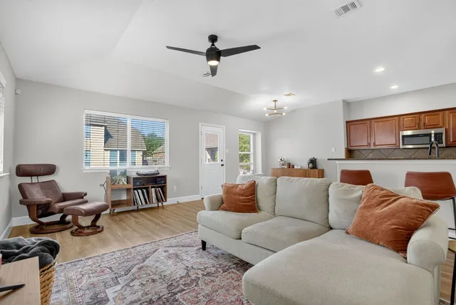 a living room with furniture ceiling fan and a rug