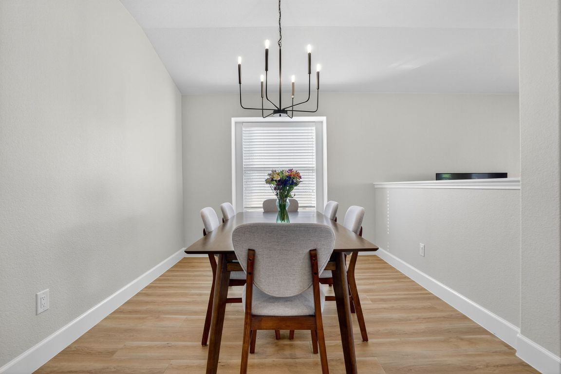394 Verano Drive Kyle, TX 78640 - Photo 12 of 25 a view of a dining room with furniture and wooden floor