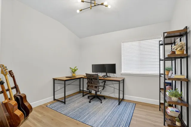 a view of a workspace with furniture and a window
