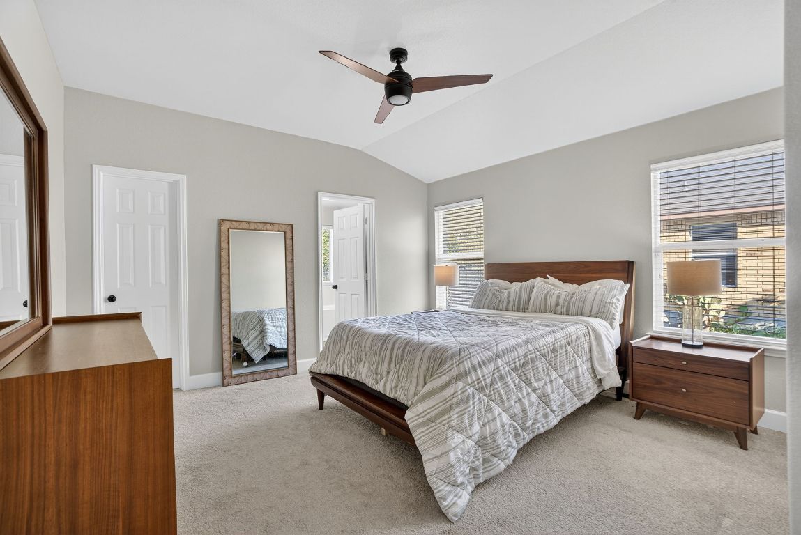 394 Verano Drive Kyle, TX 78640 - Photo 15 of 25 a bedroom with a bed a window and a chandelier