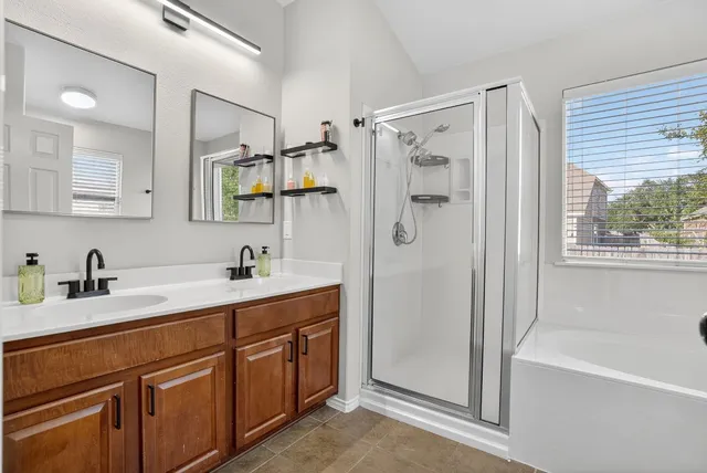 a view of bathroom with a tub sink shower and mirror