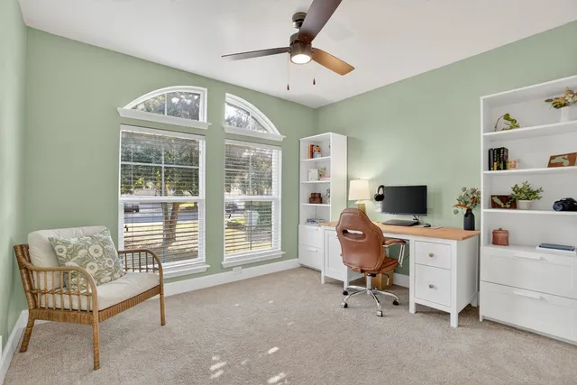 a view of a workspace with furniture and a window