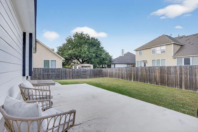 a view of a chair and table in backyard of the house