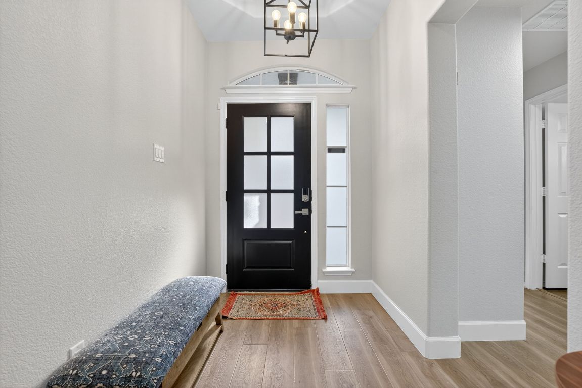 394 Verano Drive Kyle, TX 78640 - Photo 4 of 25 wooden floor in an empty room with a window