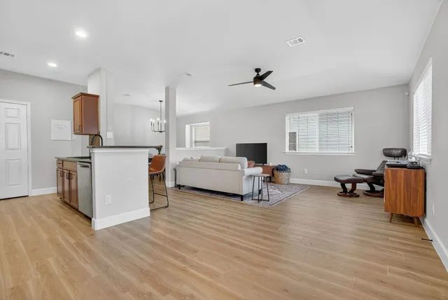 a living room with furniture and a wooden floor