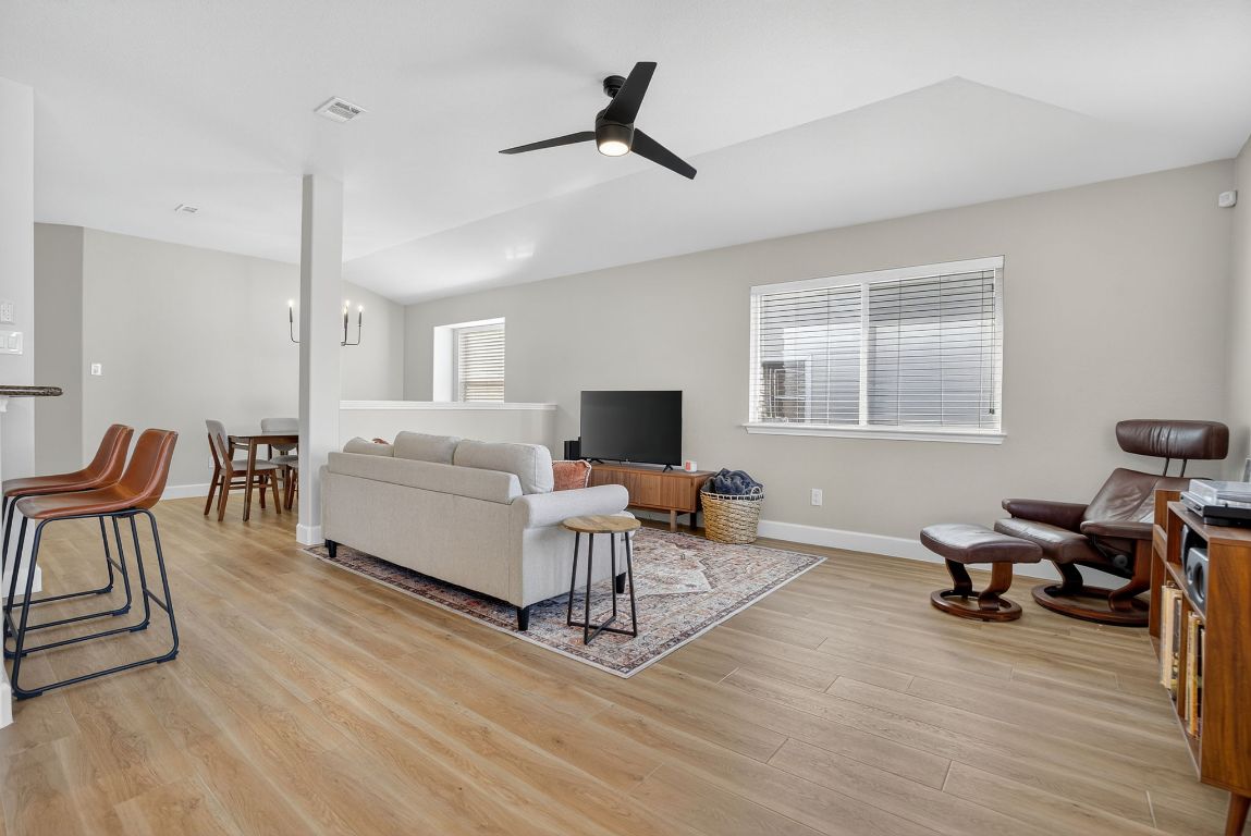 394 Verano Drive Kyle, TX 78640 - Photo 10 of 25 a living room with furniture a flat screen tv and a wooden floor
