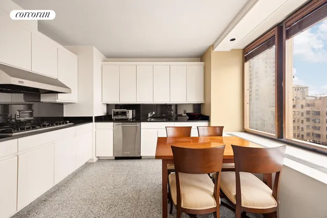 a large kitchen with stainless steel appliances kitchen island a large window in it