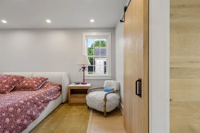 a large bedroom with a bed and wooden floor