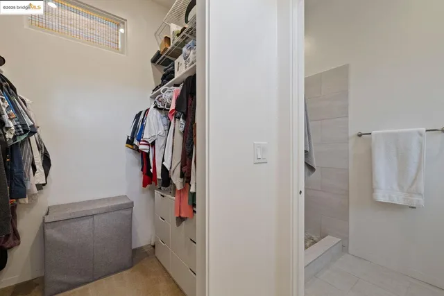 a view of walk in closet with clothes