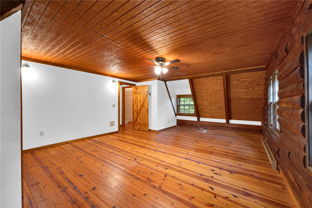 237 Spring Valley Road Liberty, SC 29657 - Photo 19 of 50 Warm wood finishes envelop this inviting bedroom, featuring polished hardwood floors and a striking slatted ceiling.