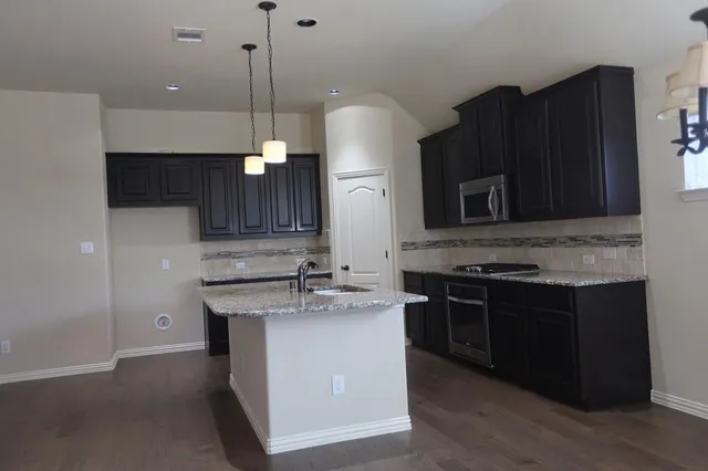 a kitchen with a sink stove and microwave